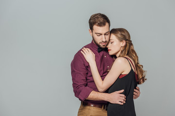 beautiful stylish young couple on love embracing isolated on grey