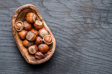Filberts or hazelnuts in the wooden bowl on the table.