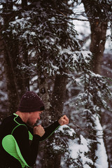 Young man shadow boxing in a forrest in the winter in Austria