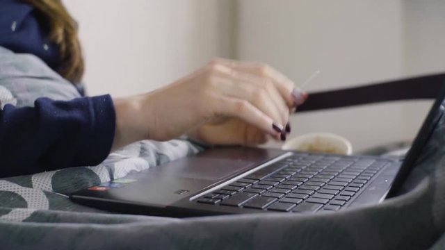 Close up shot of young woman buying goods from the internet on laptop
