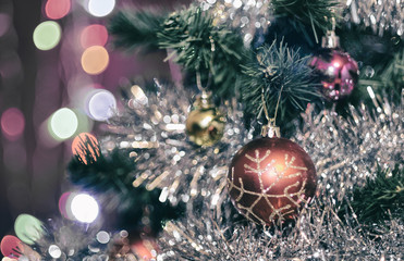 Fototapeta na wymiar Christmas decorations on a Christmas tree in shiny tinsel with beautiful bokeh