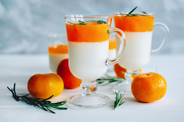 Tangerine panna cotta dessert with rosemary in wineglasses