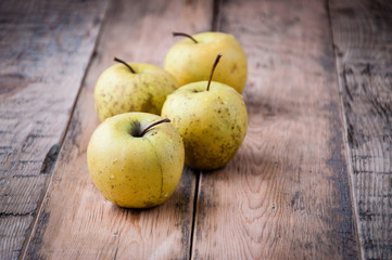 Fresh yellow apples on a wooden background