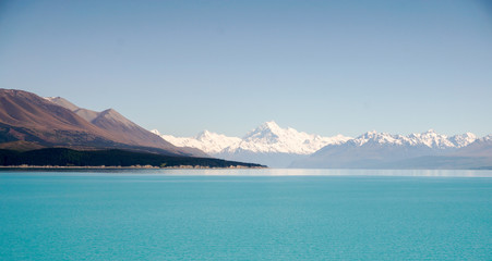 Aoraki Mount Cook and Lake Pukaki, Canterbury High Country, South Island, New Zealand. Panoramic view from Glentanner Park Centre, on a background of blue sky with clouds, snowy Southern Alps.