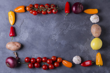 Top view of delicious ingredients for healthy cooking or salad making on slate vintage background. Bio Healthy food, herbs and spices. Organic vegetables on slate. Cooking or vegetarian food concept.