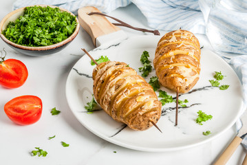 Tornado Cheesy Potatoes with Parsley and Tomatoes, on white marble background, copy space