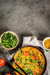 Indian food recipes, Masala Omelette with fresh vegetables - tomato, hot chili pepper, parsley, dark stone background, copy space top view