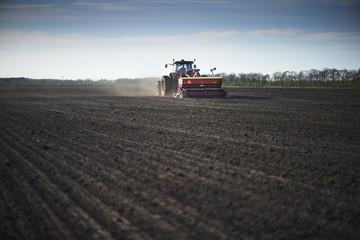 Obraz premium Red tractor plow field