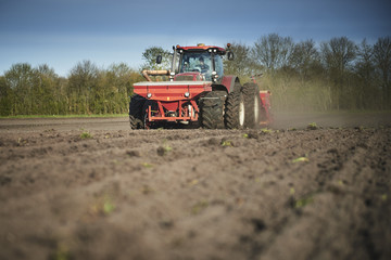 Fototapeta premium Red tractor plow field