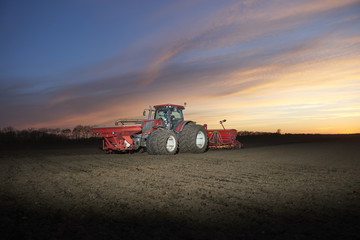 Fototapeta premium Red tractor plow field
