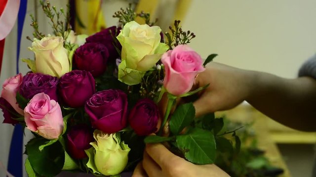 woman florist creates a flower arrangement in the basket