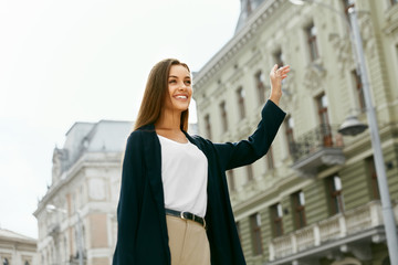 Fototapeta premium Beautiful Woman Catching Taxi Car On Street.