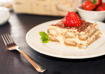 Homemade tiramisu cake decorated with strawberries Italian cuisine, Selective focus