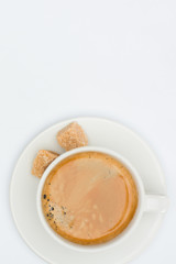 top view of cup of coffee with saucer and brown sugar isolated on white