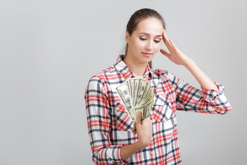 woman in a plaid shirt holding dollar bills