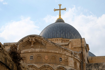Fototapeta na wymiar Golden cross on the top of Holy Sepulcher church building in Jerusalem.