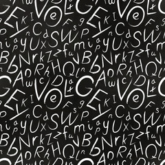 White chalk hand-drawn cursive letters on black school chalkboard with texture, seamless pattern