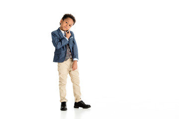 Naklejka premium adorable african american kid talking by smartphone on white