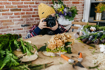 Woman taking photo of flower composition