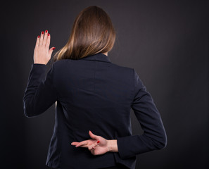 Businesswoman with crossed fingers behind her back