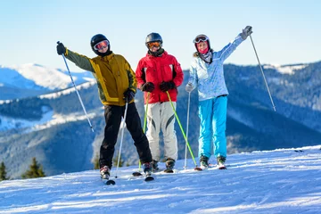 Crédence de cuisine en verre imprimé Sports dhiver Three happy skiers having fun on winter ski slope