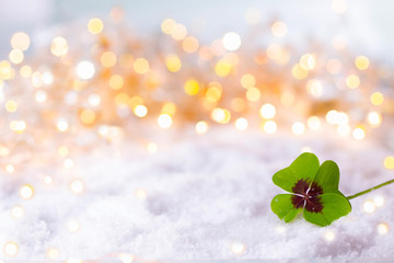 New Year Background  -  Four-leafed clover in snow landscape with bokeh lights
