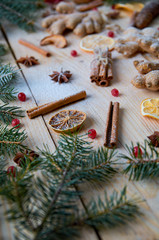 Traditional spices for mulled wine Christmas bakery orange, anise, cinnamon, ginger, viburnum on wooden background. Decorated with Christmas tree branches, pine cones. New year composition. Horizontal
