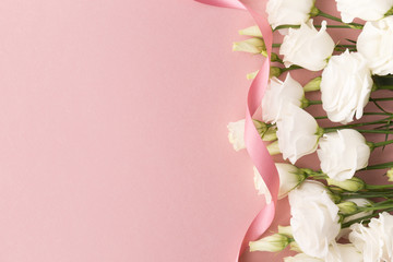 Fototapeta na wymiar White roses and pink ribbon