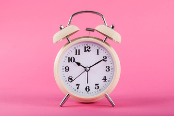 Old clock with bells isolated on pink background
