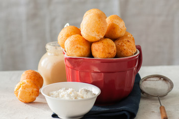 Small cottage cheese doughnuts (castgnole) served on a red  bowl.