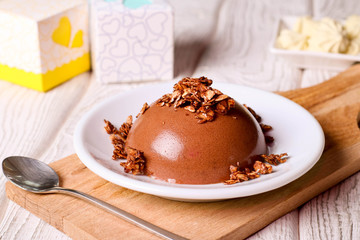 Chocolate panna cotta on a white plate