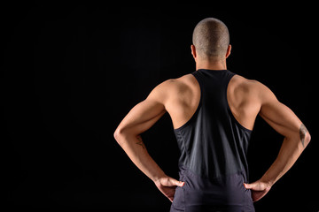 rear view of muscular african american sportsman standing isolated on black