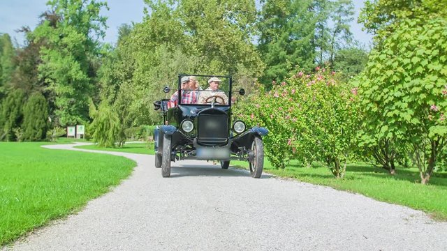 Driving through marvellous park with magnificent first black wooden car that originates from American Ford Motor Company.