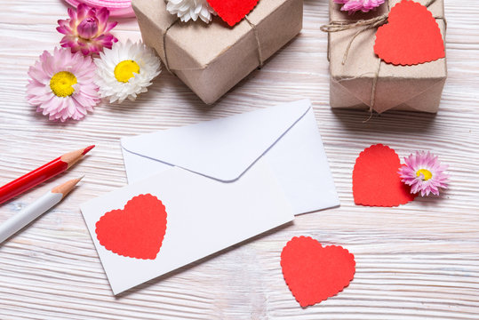 Preparing Valentine day gift, gift boxes and envelope on wooden background