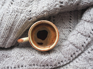 Winter coffee. A Cup of coffee in a knitted sweater in the shape of the eye. 

