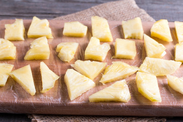 Frozen slices of frozen pineapple on a cutting board