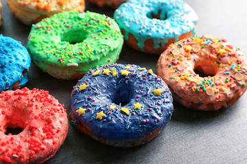 Fresh yummy colorful donuts on grey background