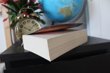 Book on black table and clock 