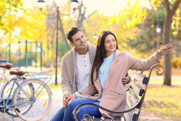 Obraz premium Young couple resting after bike ride in park