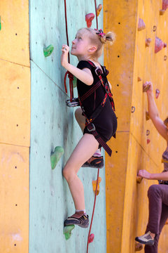  little girl climbing up the wall
