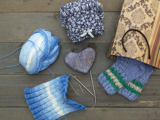 Knitted socks and scarf on a wooden background. 