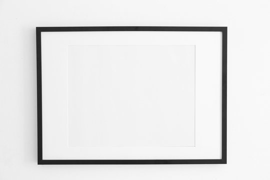 Empty black frame on white wall