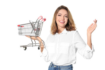 Young woman holding small shopping cart on white background