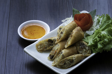 Spring roll on white dish with sweet and spicy in the kitchen / Selective focus image ans