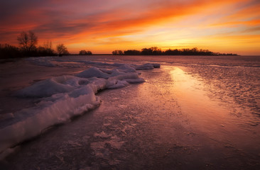 Winter landscape with sunset fiery sky.