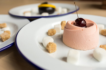 Variety of desserts on the table with white plates and marshmallows. Cherry, chocolates