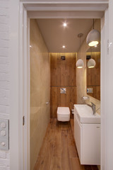 A bathroom with a wooden floor and a wooden wall 