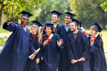 students or graduates with diplomas taking selfie