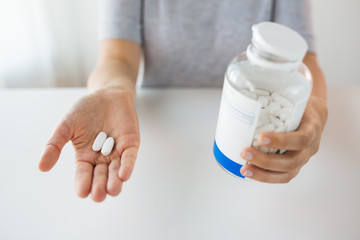 close up of hands holding medicine pills and jar