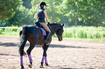 Young lady riding a horse at equestrian school. Training process